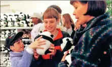  ?? WANG YAN / XINHUA ?? Visitors check out dolls after a pair of giant pandas settled at an Atlanta zoo in 1999 in a sign of Sino-US friendship.