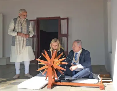  ?? AFP ?? Benjamin Netanyahu and his wife Sara sit near a spinning wheel as Narendra Modi looks on during a visit to the Sabarmati Ashram in Ahmedabad on Wednesday. —