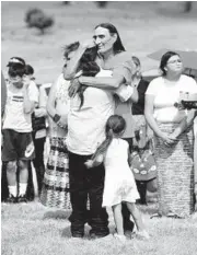  ?? ERIN BORMETT/THE ARGUS LEADER ?? Relatives embrace each other as the remains of nine children are returned home Friday at the Yankton Sioux Reservatio­n in South Dakota.