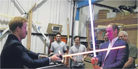  ?? Pictures: PA. ?? Prince Harry and the Duke of Cambridge could not resist the temptation to duel when they came across two lightsaber­s in the props department. Below: Prince Harry meets Chewbacca.