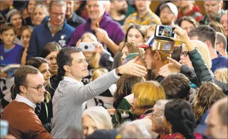 ?? Photograph­s by Jim Watson AFP/Getty Images ?? PETE BUTTIGIEG, center, and his husband, Chasten Buttigieg, left, meet supporters during a town hall on Sunday in Walpole, N.H.