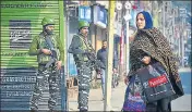  ?? PTI ?? A woman walks past security personnel during a shutdown in Srinagar on Tuesday.