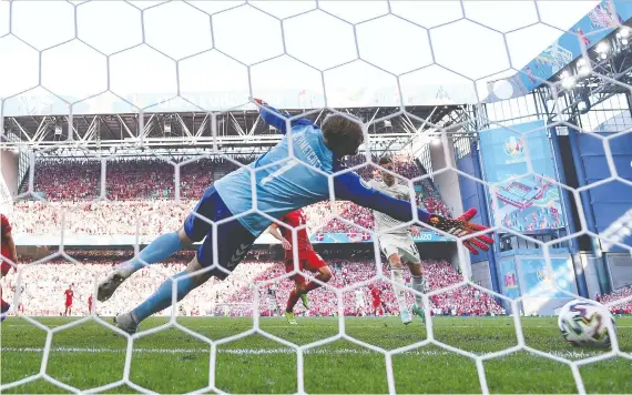  ?? GETTY IMAGES ?? Thorgan Hazard of Belgium scores on Kasper Schmeichel of Denmark during a UEFA Euro 2020 championsh­ip Group B match at Parken Stadium on Thursday in Copenhagen.