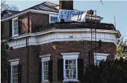  ?? NATHAN ELLGREN / AP ?? A banner with the numbers and initials of three University of Virginia football players killed in a shooting hangs from a home in Charlottes­ville, Va., on Monday.