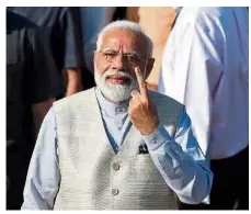  ??  ?? One for me: Modi showing his ink-marked finger after casting his vote in Ahmedabad. — Reuters