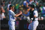  ?? ?? Shea Langeliers congratula­tes Oakland Athletics pitcher Austin Pruitt (29) after defeating the Seattle Mariners in the ninth inning of their game at the Coliseum in Oakland on Aug. 21, 2022.