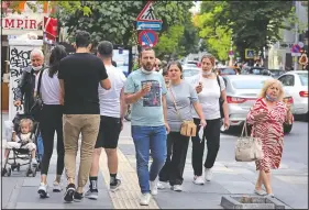  ?? (AP/Burhan Ozbilici) ?? People who aren’t wearing face masks to protect against the spread of coronaviru­s walk Sunday in Ankara, Turkey. Turkish authoritie­s have made wearing masks mandatory in three major cities to curb the spread of covid-19 following an uptick in confirmed cases since the opening of many businesses.