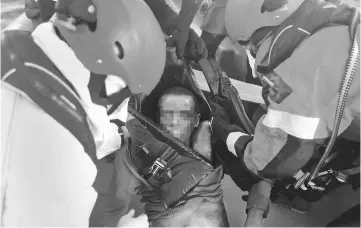  ??  ?? Lifeguards from the Spanish NGO Proactiva Open Arms collect the body of a dead migrant in central Mediterran­ean Sea off the Libyan coast. — Reuters photo