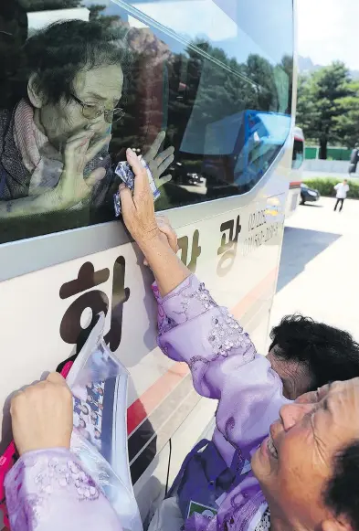  ?? LEE JI-EUN / YONHAP VIA THE ASSOCIATED PRESS ?? North Korean Kim Kyong Sil, 72, reaches up to touch the bus window where her South Korean mother Han Shin-ja, 99, sits after a rare family reunion meeting at Diamond Mountain resort in North Korea Wednesday.