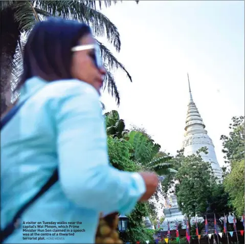  ?? HONG MENEA ?? A visitor on Tuesday walks near the capital’s Wat Phnom, which Prime Minister Hun Sen claimed in a speech was at the centre of a thwarted terrorist plot.