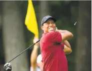  ?? Doug Mills / New York Times ?? Tiger Woods tees off on the 16th hole en route to a 6-under-par 64 final round to finished second.