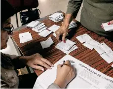  ?? /EFE ?? Miembros de mesa y testigos participan en el cierre de mesas y auditoría de actas.