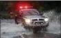  ?? DAVE SCHERBENCO — THE CITIZENS’ VOICE VIA AP ?? A member of the Plymouth Township Fire Police makes his way through water running across U.S. Route 11 Wednesday evening in West Nanticoke, Pa. as extended downpours caused flooding from mountainsi­de runoff.