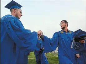  ?? DANA JENSEN/THE DAY ?? Bret Wood, left, shakes hands with Peter Turello, right, as he passes by for the recessiona­l at the end of the Waterford High School commenceme­nt Thursday. Go to www.theday.com for a list of graduates and more photos.