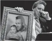  ?? SUSAN WALSH/THE ASSOCIATED PRESS ?? Neil Heslin, the father of a six-year-old boy who was slain in the Sandy Hook massacre in Newtown, Conn., on Dec. 14, holds a picture of himself with his son Jesse.