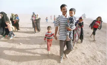  ?? — Reuters ?? Civilians return to their village after it was liberated from IS militants, south of Mosul, Iraq.