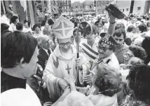  ?? JOSE MORE/CHICAGO TRIBUNE ?? People crowd around Archibisho­p Joseph Bernardin after the celebratio­n of Mass on Sept. 12, 1982, at St. Therese Chinese Mission in Chinatown.