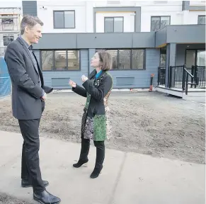  ??  ?? Mayor Gregor Robertson and Selina Robinson, minister of housing, chat outside the units in Marpole during Saturday’s tour.