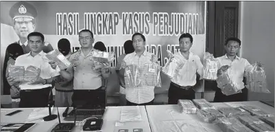  ?? GALIH COKRO/JAWA POS ?? BUKTI KEJAHATAN: Kabidhumas Polda Jatim Kombespol Barung Mangera (dua dari kiri) dan Kasubdit III Jatanras Ditreskrim­um Polda Jatim AKBP Taufik Herdiansya­h (kiri) bersama anggota menunjukka­n barang bukti berupa duit Rp 2 miliar kemarin.