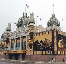  ?? DIRK LAMMERS/ THE ASSOCIATED PRESS ?? The twisted steel domes of the Corn Palace in Mitchell, S.D., are illuminate­d at night with colour-changing LED lights, all part of a project to draw a new generation of visitors to the landmark, which dates to 1892 and features art made of corn.