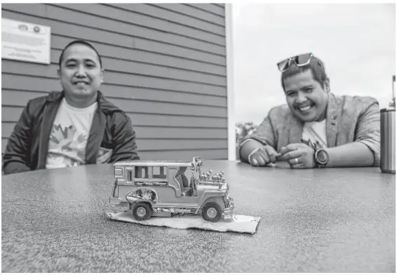  ?? JESSICA SMITH • CAPE BRETON POST ?? Jon Morales, left, and Julius Garcio look fondly at a model of a Jeepney, a popular mode of transporta­tion in the Philippine­s.