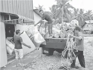  ??  ?? BANTU: Seorang anggota Jabatan Penerangan Daerah Simunjan, Zainal Abidin (kanan) membantu menyediaka­n kemudahan dan keperluan kepada mangsa banjir di Dewan Kampung Segali semalam.