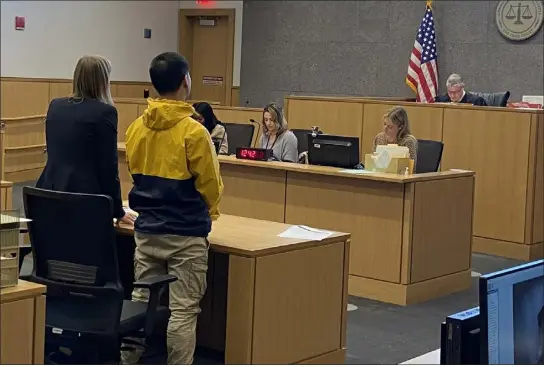  ?? MELANIE GILBERT — LOWELL SUN ?? Sovandara Khiaosoth, 29, of Lowell, in the yellow jacket, stands with his attorney, Eileen Morrison, in Judge Stephen Geary’s courtroom at Lowell District Court Monday for a dangerousn­ess hearing on his alleged connection with a March 10shooting in the city’s Centralvil­le neighborho­od. Khiaosoth was denied bail and a probable cause hearing is scheduled for April 19.