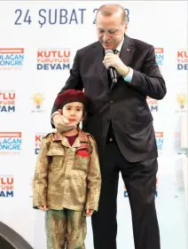  ??  ?? Turkish President Recep Tayyip Erdogan holds Amine Tiras, a young girl in military uniform as he speaks to his ruling party members, in Kahramanma­ras, Turkey. After trying to comfort the girl by kissing her on both cheeks, Erdogan told the crowd that...