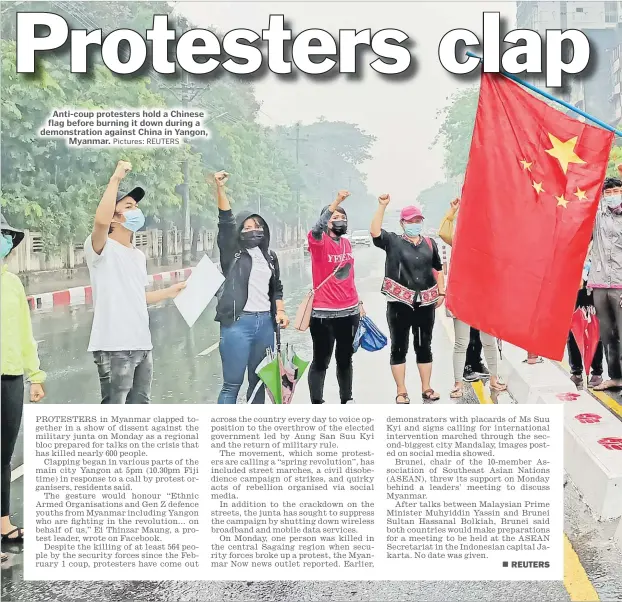  ?? Pictures: REUTERS ?? Anti-coup protesters hold a Chinese flag before burning it down during a demonstrat­ion against China in Yangon, Myanmar.