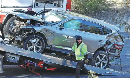  ?? REUTERS ?? The SUV of Tiger Woods is loaded onto a recovery truck after being involved in a single-vehicle accident in Los Angeles, California, on Tuesday. The American golf great was rushed to hospital after sustaining severe injuries to his legs.