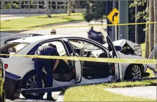 ?? BRUCE R. BENNETT / THE PALM BEACH POST ?? Palm Beach Gardens police examine an Audi that crashed in a shooting incident Friday outside The Gardens mall. Authoritie­s had not identified the two people involved in the incident.