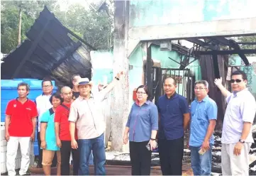  ??  ?? Henry (fifth left) points to what remains of the burnt house. Rimet is on his right.