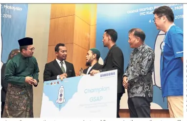  ?? — LOW LAY PHON/The Star ?? Loqman Hakim (2nd from left) handing the cheque to Mohd Rashid (3rd from left), while Samsung’s Roh (2nd from right) and others look on.