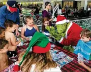  ?? COURTESY ?? The Grinch helps with crafts but, known for mischief, disrupted some of the kids during craft time at Cherokee County Parks and Recreation Aquatic Center’s 2019 Grinch event, the last one before the pandemic.