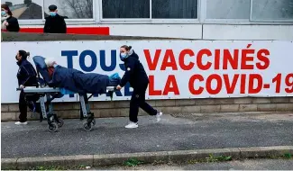  ?? ?? Une femme est transporté­e sur un brancard au centre de vaccinatio­n COVID-19 du Groupe Hospitalie­r Sud Ile-de-France à Melun, dans la banlieue de Paris, février 2021.