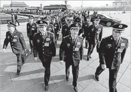  ?? ANDY WONG/AP ?? Delegates from China’s People’s Liberation Army arrive Saturday to attend a plenary session of the National People’s Congress in Beijing. The congress opens Sunday.