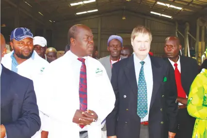  ??  ?? Seed Co group chairman Dave Long (right) takes State Governor of the Tranz Nzoia county Patrick Simuyu (in white jacket) through the newly constructe­d plant in Kenya last week