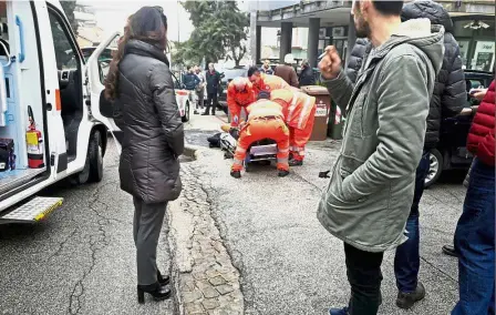  ?? — Reuters ?? Scene of the crime: Bystanders watching as healthcare personnel attend to an injured person after the attack in Macerata, Italy.
