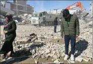  ?? ASSOCIATED PRESS ?? Taha Erdem, 17, right, his mother Zeliha Erdem, left, and father Ali Erdem stand next to the debris from a building where Taha was trapped after the quake in Turkey.