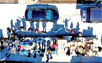  ?? — AFP photo ?? Volunteers direct traffic as they pass out water during a water distributi­on event at the Fountain Life Center in Houston, Texas.