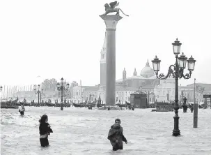  ?? — Gambar Reuters ?? BANJIR: Orang ramai meredah air yang menenggela­mi Dataran Saint Mark di Venice, kelmarin.