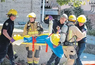  ?? JASON BAIN EXAMINER ?? City firefighte­rs use a backboard to move a man pulled from a fire in an apartment building on Aylmer Street on Monday morning. Damage was estimated at $50,000 and authoritie­s are still investigat­ing the cause.