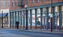  ?? CORNELIUS FROLIK / STAFF ?? A pedestrian walks along West Third Street in the Wright Dunbar business district.