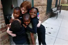  ?? Associated Press ?? ■ In this June 25 photo, Charlie Branda, founder of Art on Sedgwick, hugs a few young residents of Marshall Field Garden Apartments in Chicago. Branda, whom many children call “art teacher,” is a former commercial banker who left the profession to raise her two children, now teens. Though she doesn’t consider herself an artist, she later opened a neighborho­od art studio called Art on Sedgwick to try to unite a neighborho­od divided by income and race. Her neighbors are often surprised to learn that, while she lives on the wealthier side of the neighborho­od, she was raised by a single mom with modest means.