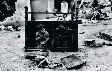  ?? KIM MANRESA ?? Dos niños juegan entre basuras y muebles abandonado­s, una de las fotos del libro
Les barraques de Santa Engràcia