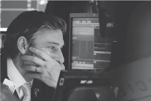  ?? RICHARD DREW / THE ASSOCIATED PRESS ?? Trader John Romolo grimly works the floor of the New York Stock Exchange during Thursday’s bad session.