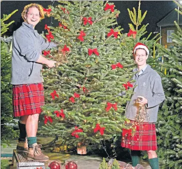  ??  ?? Kilted brothers Sam and Josh Lyle decorate one of their trees at Pines And Needles