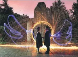  ?? CAO ZHENGPING / XINHUA ?? Senior students at the School of Design and Art at the University of South China in Hengyang, Hunan province, pose for graduation pictures. The students, in academic robes, seem to have wings and “power” rings.