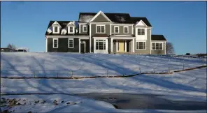  ?? AP ?? Long-term mortgage rates have continued their fall this week, creating incentive for sales of homes like this one surrounded by snow last month in Natick, Mass.