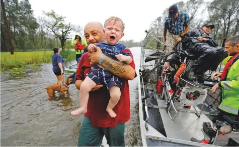  ?? Reuters ?? One-year-old Oliver Kelly cries as he is carried off the sheriff’s hovercraft during his rescue from rising flood waters in the aftermath of Hurricane Florence in Leland, North Carolina, United States, on Sunday.